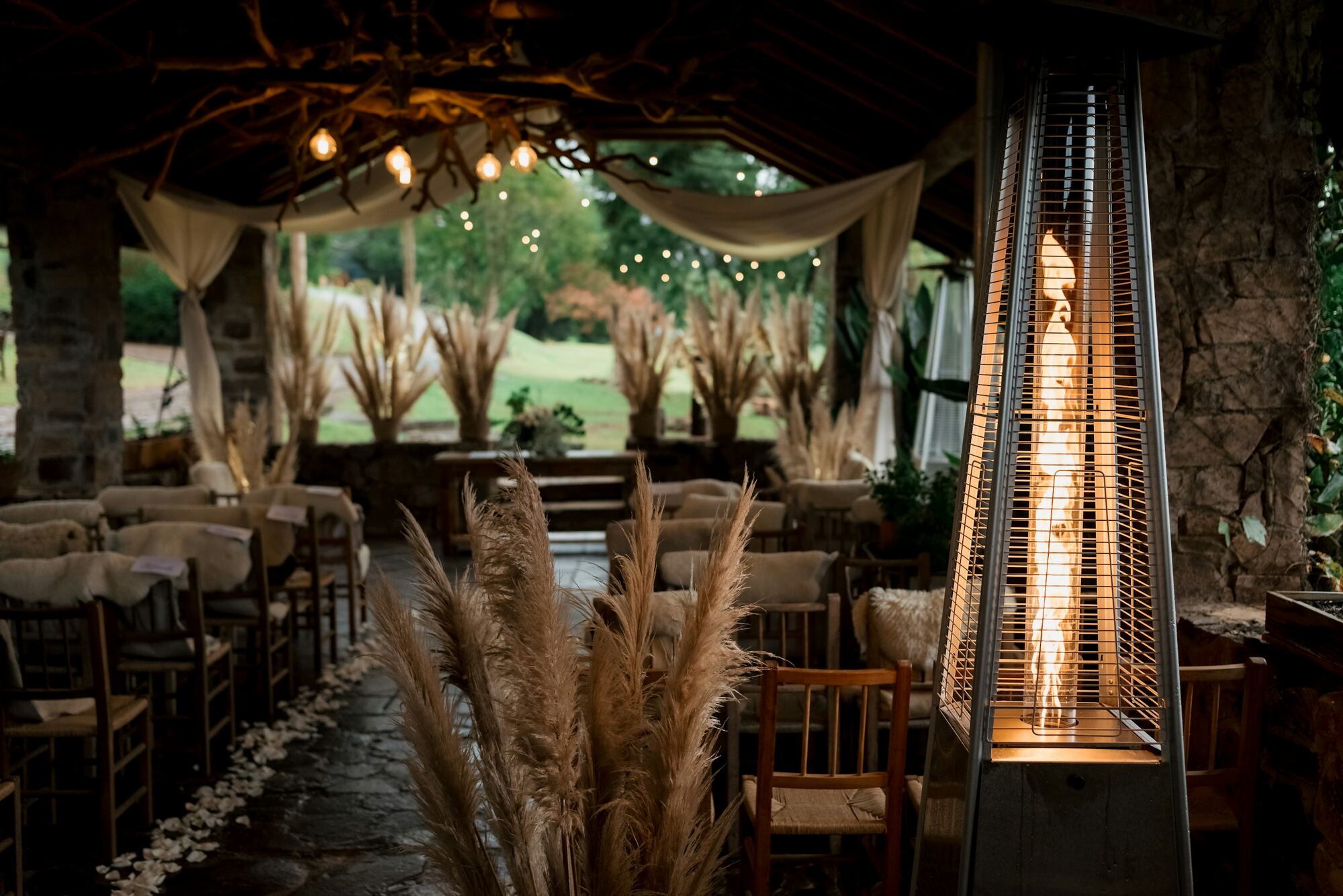 Montaje de ceremonia con sillas de madera y pampas